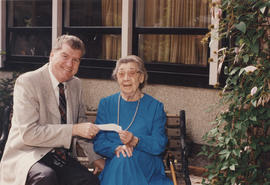 Presentation of [possibly a cheque] to unidentified woman