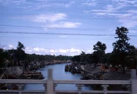 View from a bridge overlooking a river with boats on both banks