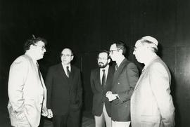 [Five unknown men standing in a semi-circle and talking]