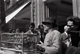 [Unidentified man with cage of birds]