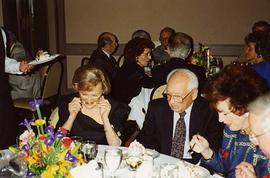 [Dr. Irving and Phyliss Snider sitting at a table eating at an unknown event]