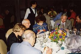 [Dr. Irving and Phyliss Snider sitting at a table eating at an unknown event]