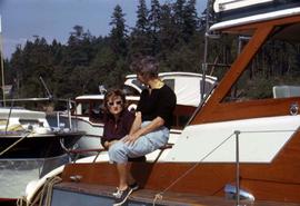 Phyliss Snider and an unknown woman sitting on a boat with other boats in the background