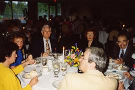 [Unknown people sitting around a table talking]