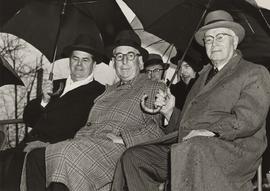 Unidentified men under umbrellas