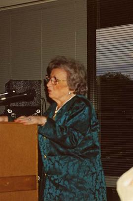 [Esther Dayson speaking at a podium at an unknown event]