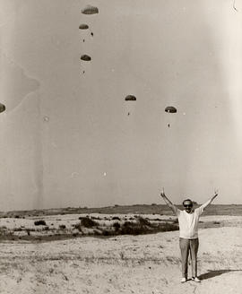 'Israeli Paratroopers,' [Ben Wosk ?] standing in open field, parachutists in the sky above him