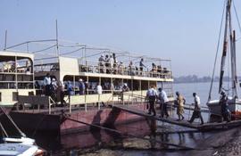 Unidentified people walking up a gangplank of a river cruise boat