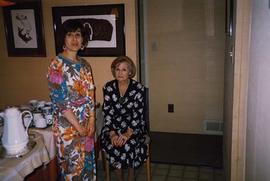 [Phyliss Snider sitting on a chair and an unknown woman standing next to her]