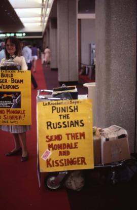 Sign that reads: "La Rouch Says: Punish the Russians, Send Them Mondale and Kissinger"