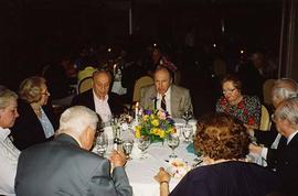 [Group of unknown people sitting around a table at an unknown event]