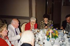 [Unknown people sitting around a table eating]