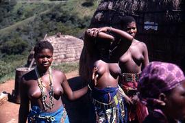 Unidentified South African women wearing traditional ethnic attire, one of which has her arms ove...