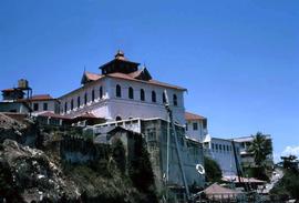 White house with red tiled roof on a cliffside