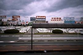 View of a parking lot with signs in the background