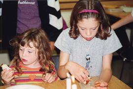 [Two unidentified girls eating challah, apples and honey]