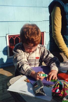 [Jesse Sheftel making decorations for sukkah]