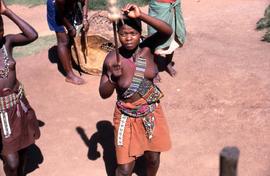 Unidentified South African woman in traditional ethnic attire holding a fighting stick