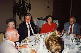 [Unknown people sitting around a table at an unknown event eating dessert]