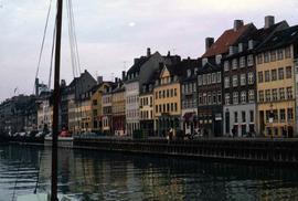 Boat mast with water and buildings in the background