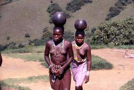 Unidentified South African women balancing jugs on their heads, in traditional ethnic attire