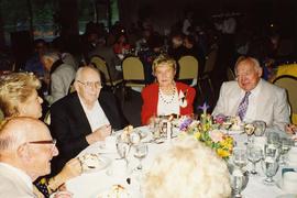 [Unknown people sitting around a table eating and talking]