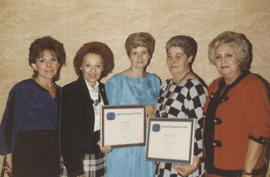 Five women, two holding certificates