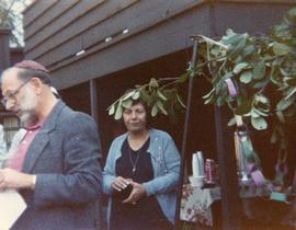 Unidentified man and woman standing near sukkah