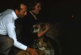 Unknown man and woman playing with two of the Snider's dogs