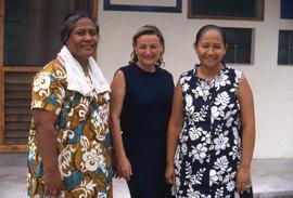 Phyliss Snider standing in between two other women in front of a house