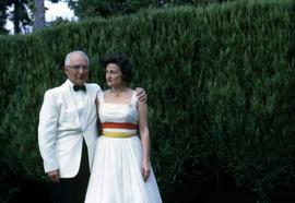 Dr. Irving and Phyliss Snider posing for the camera next to a hedge