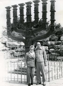 [Ben and Esther Dayson posing in front of a large menorah]