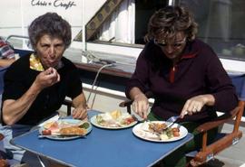 Phyliss and an unknown woman sitting at a table eating