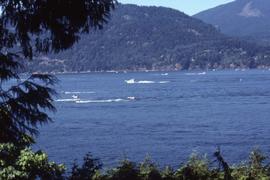 Body of water with boats and mountains in the background