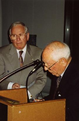 [Joe Segal standing next to Dr. Irving Snider who is looking down at the podium he is standing be...