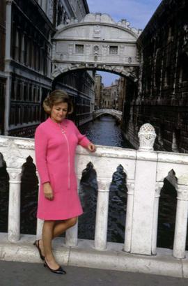 Phyliss Snider posing in front of a canal with an arch in the background