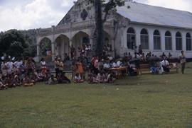 Group of people gathered on the lawn of a building