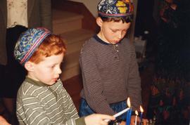 [Jesse and Benjamin Sheftel light the Chanukah candles]