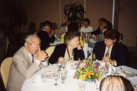 [Unknown people sitting around a table at an unknown event eating dessert]