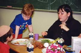 [Two children and a woman eating]