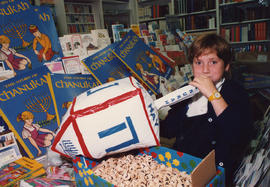 Esther Edel surrounded by Hannukah books and novelties