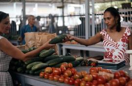 Phyliss Snider buying cucumbers at a market