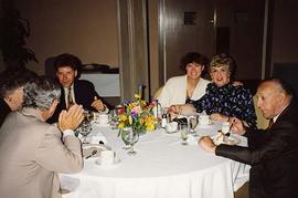 [Unknown people sitting around a table at an unknown event]