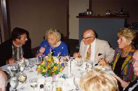 [Unknown people sitting around a table eating and talking]