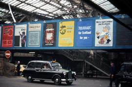 Automobile in a glassed in building with an array of signs