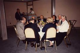 [Unknown people sitting around a table eating]