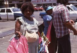 Woman holding many hangers with clothes on them