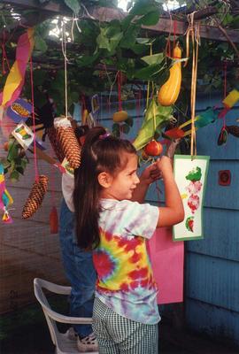 Unidentified girl decorating sukkah